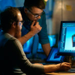 Perfecting Your Product: How to Prevent the Most Common Defects in Plastic Two men looking at a computer screen.