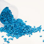 OEMs and molders seek creative solutions during resin shortage A frosted white plastic cup spills small blue resin pellets.